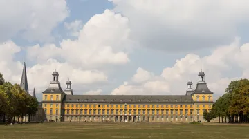 Large yellow building under cloudy sky.