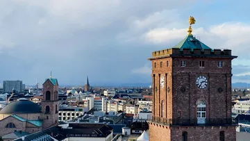 Uhrturm überblickt Stadtgebäude.