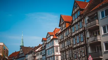 Fachwerkhäuser mit roten Dächern unter blauem Himmel.