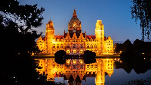 Beleuchtetes Gebäude spiegelt sich im ruhigen See.