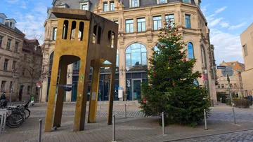 Sculpture and Christmas tree in city square.