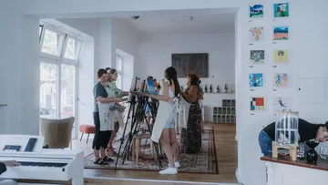 Künstler im hellen Studio malend.