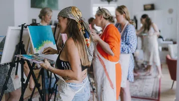 Frauen malen auf Leinwänden im Kunstkurs.