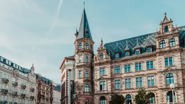 Historisches Gebäude mit Turm, klarer Himmel.