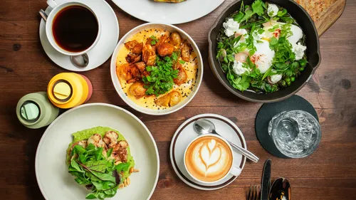 Variety of breakfast dishes on wooden table.