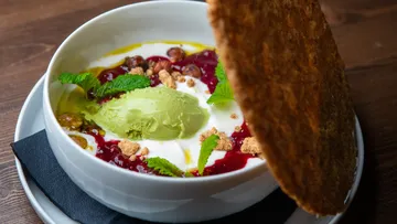 Dessert bowl with avocado, berry sauce, mint garnish.