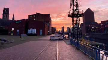 Sonnenuntergang über Industriebereich mit Kran.