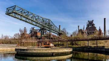 Industrial crane over water in factory setting.