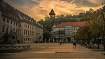 Uhrturm auf Stadtplatz bei Sonnenuntergang.