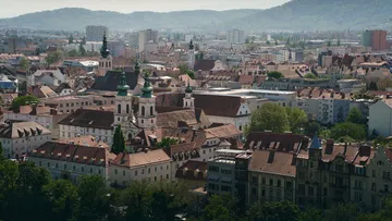 Cityscape with historic buildings and mountains.