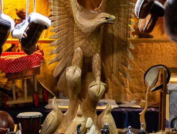 Wooden eagle sculpture displayed in a market.