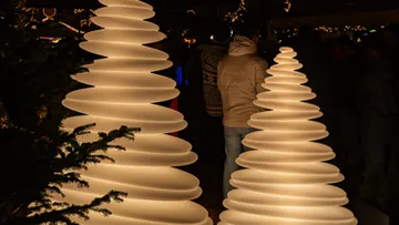 Leuchtende Spiraltannen auf einem Festmarkt.