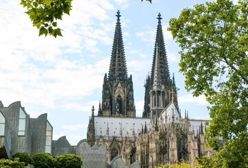 Cathedral towers amid trees and sky.