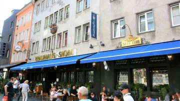 People dining outside a city brewery.