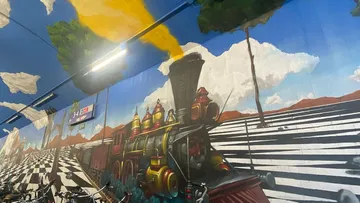 Mural of steam train in tunnel.