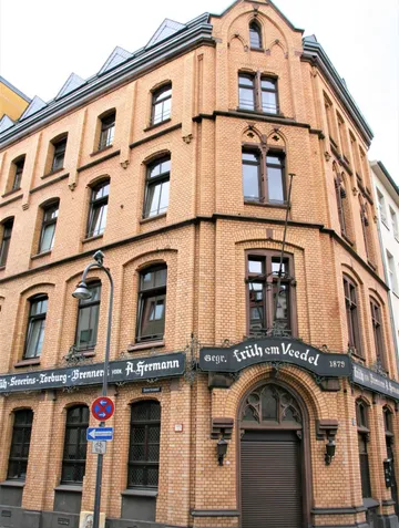 Backsteingebäude Ecke mit Rundbogenfenstern.