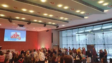 Crowd socializing in a conference room.