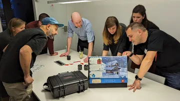 Gruppe untersucht Brettspiel im Büro.