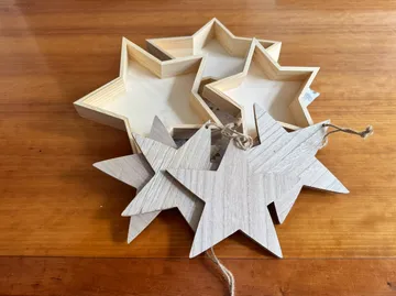 Wooden star shapes stacked on wooden surface.