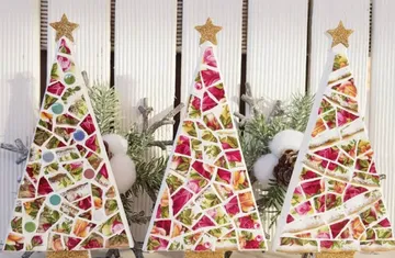 Drei Mosaik-Weihnachtsbäume mit festlicher Dekoration.