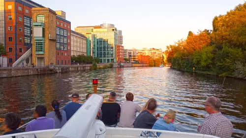 People boating on canal near buildings.