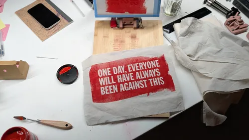 Printed quote on messy art workspace.