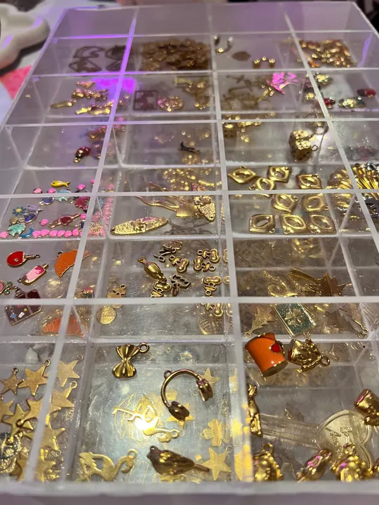 Kleine Anhänger in Plastikbox sortiert.