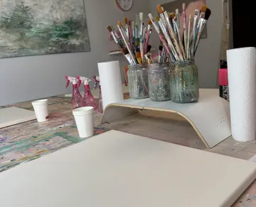 Pinsel in Gläsern auf einem Kunsttisch.