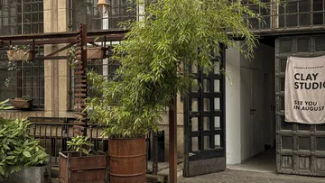 Studio entrance with plants and sign outside.