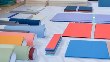 Colorful paper and fabric rolls on a table.