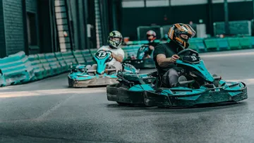 Gokarts fahren auf einer Indoor-Strecke.