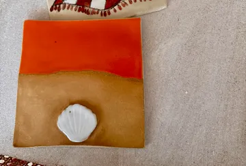 Square ceramic tile with shell design.