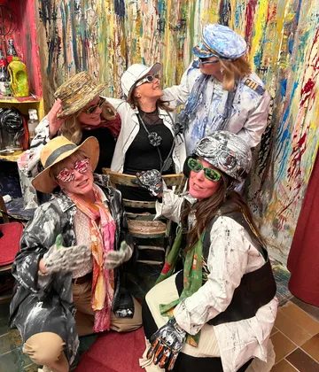 Group celebrating in colorful, artistic room.