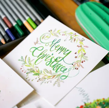 Karte mit 'Merry Christmas'; Stifte daneben.