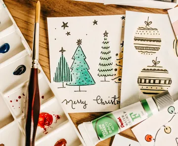 Christmas cards being painted with watercolor set.