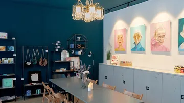 Art studio with paintings and table.