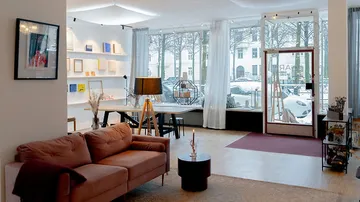 Gemütliches Wohnzimmer mit großen Fenstern und Dekor.