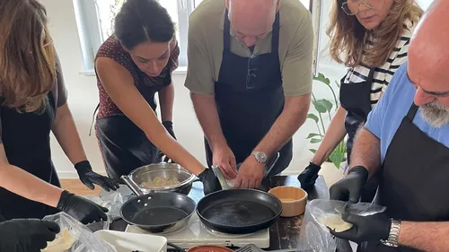 Fünf Personen bereiten Essen in der Küche vor.