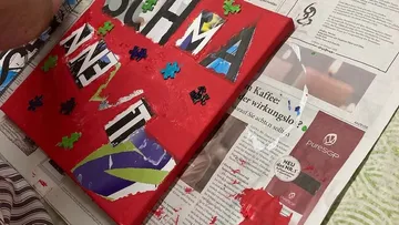 Collage-Kunst auf roter Leinwand mit Zeitung.