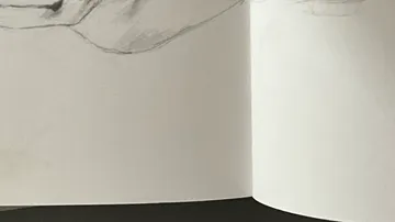Sketchbook with pencil drawing on paper.