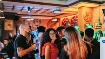 People socializing at crowded bar indoors.