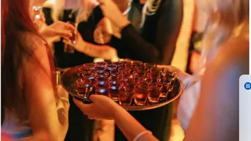 Tray of drinks served at crowded party.