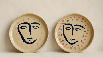 Zwei dekorative Teller mit Gesichtsmotiven.