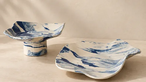 Two marbled ceramic plates on a tabletop.