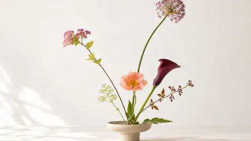 Blumen in Keramikvase auf Tisch arrangiert.