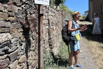 Person geht neben Steinmauer im Freien.