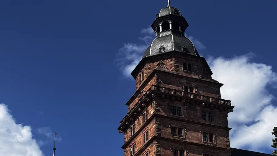 Historic tower with spire against a clear sky.
