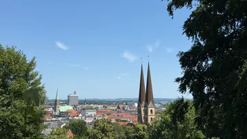 Towers overlooking cityscape with trees nearby.