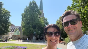 Couple smiling with a church background.