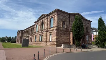 Altes Steingebäude mit Rundbogenfenstern.